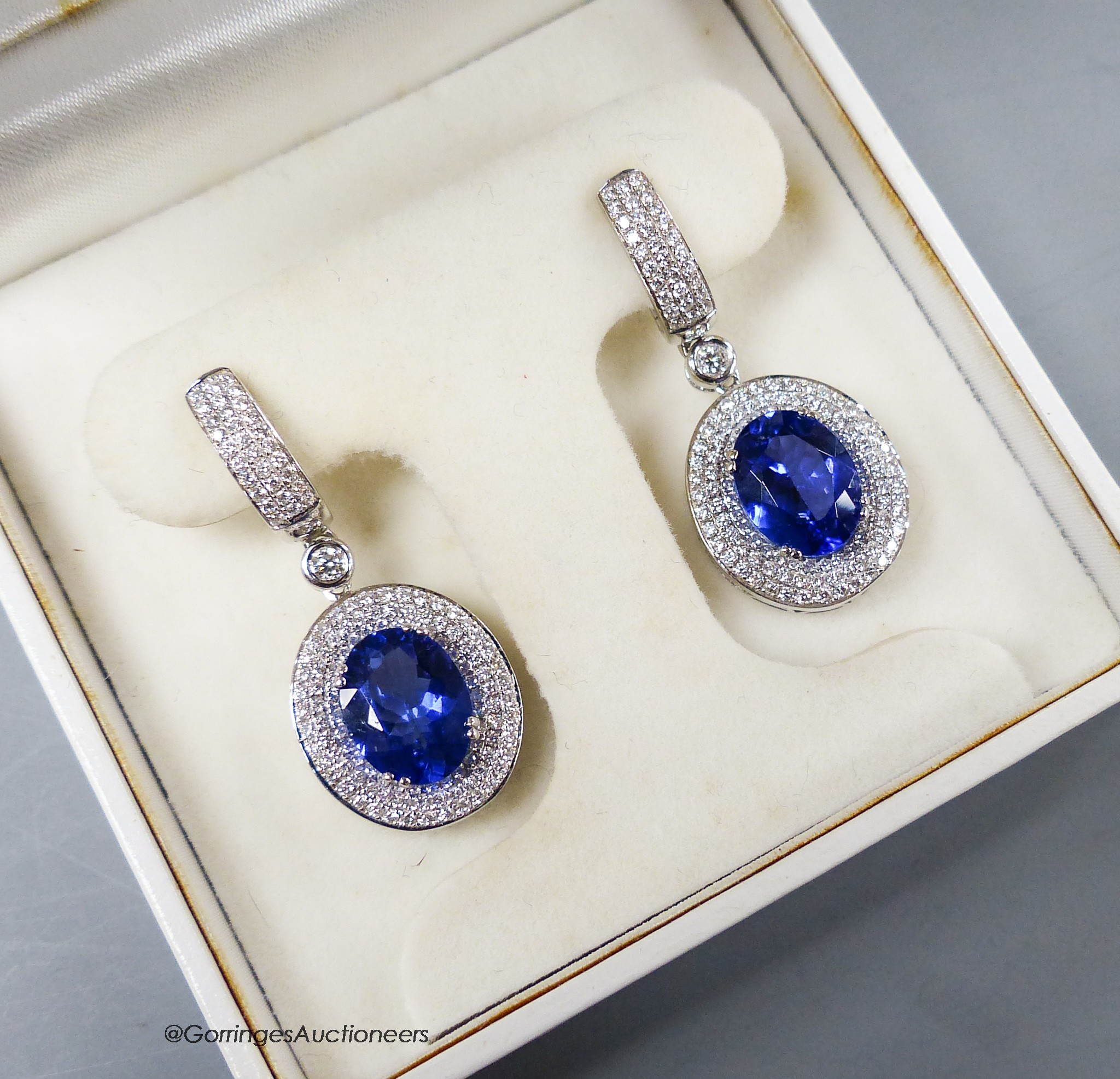 A modern pair of white metal (stamped 18k 750) tanzanite and diamond chip set oval cluster drop earrings, cluster 15mm, gross weight 10.4 grams.